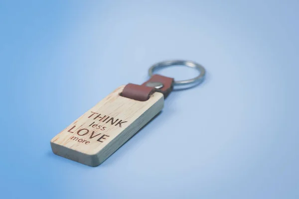 Close Key Chain Words Think Less Love More Blue Background — Stock Photo, Image