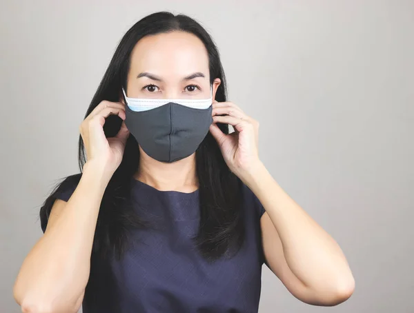 Portrait of Asian woman wearing  double face masks  or two face masks for better protection  from coronavirus or covid-19 outbreak - concept of safety, healthcare, medical and hygiene.
