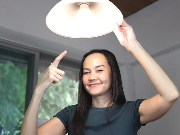 아시아 가집에 전구를 바꾸고 카메라 전등을 가리키는 — 스톡 사진