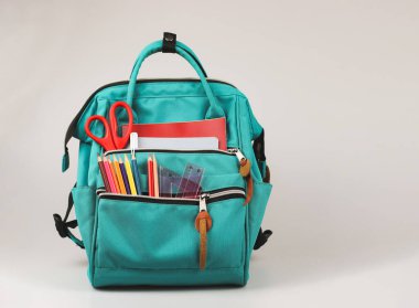 Okul kavramına geri dönelim. Okul malzemeleriyle dolu sırt çantasının ön görüntüsü..