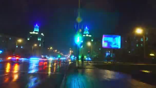 Timelapse, hyperlapse, fast traffic along the avenue and streets of the night city during the cold autumn rain through bright multicolored lights of windows, advertisements, lanterns, car headlights — Stock Video