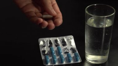 Sporcu yoldaş kapsüllerde vitamin ve mineraller alır ve bardaktan suyla yıkanır.