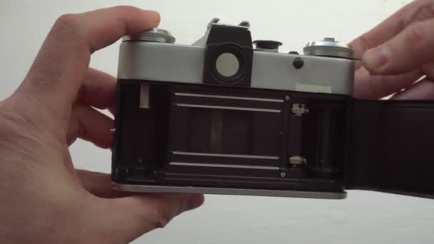 Un homme tient un vieil appareil photo soviétique appuie sur la descente de l'obturateur et le rideau est abaissé avec une exposition de fond pour une photographie — Video