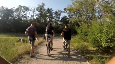 Bisikletçiler parkta bisiklet sürerler.