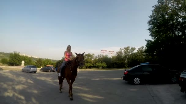 Fille à cheval sur le parking de voitures — Video