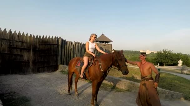 Ein Mädchen mit einer Waffe auf einem Pferd — Stockvideo