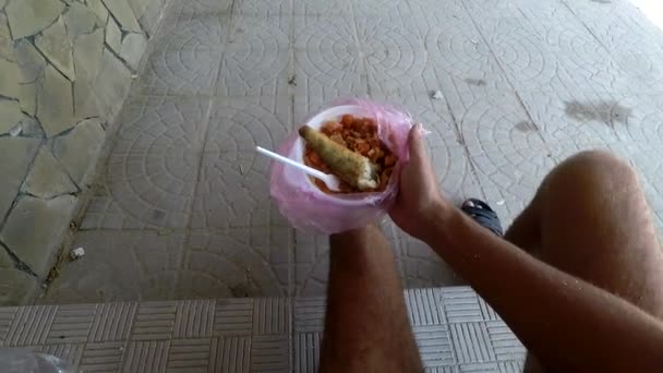 Un homme tient une assiette de nourriture de rue — Video