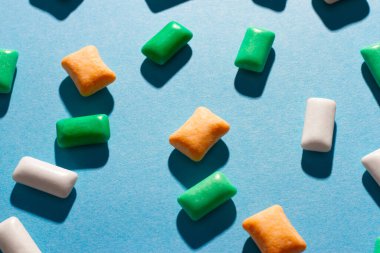 Mavi arka planda çok renkli sakız.