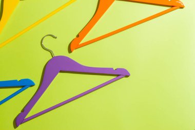 Yeşil arka planda çok renkli askılar.