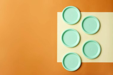 Sarı ve turuncu arka planda plastik kaplar