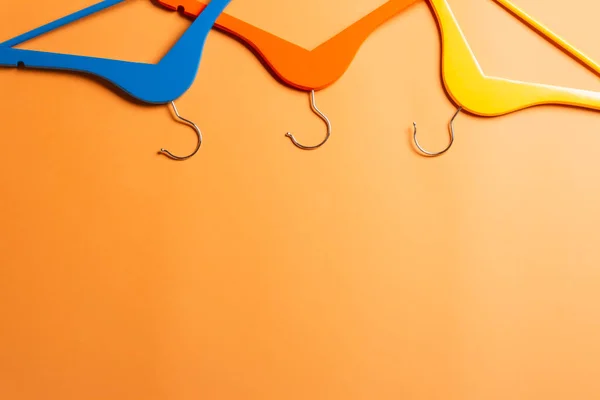 Разноцветные Вешалки Оранжевом Фоне — стоковое фото