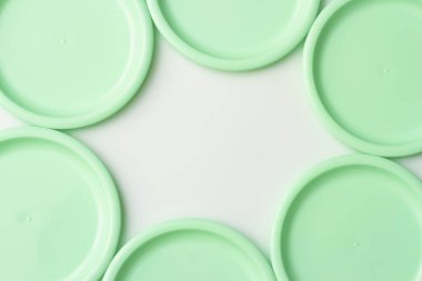 Beyaz arkaplanda nane renginde plastik tabaklar.