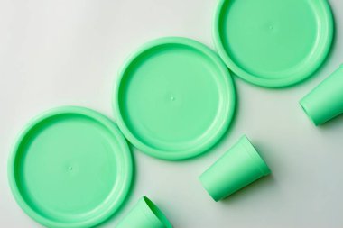 Beyaz arkaplanda nane renginde plastik tabaklar.