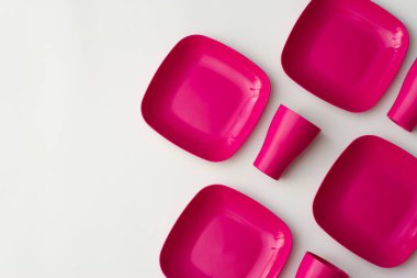 Mor plastik plakalar ve fincanlar mavimsi bir arkaplanda.