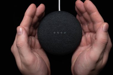 Google Home Mini kömür akıllı hoparlör kullanan kişi