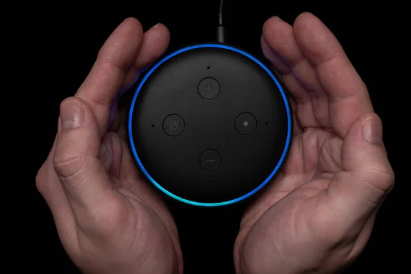 Osoba korzystająca z podświetlanego głośnika Amazon Echo Dot smart. Obrazek Stockowy