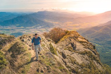 Dağlarda yürüyüş yapan yakışıklı genç adam. Macera yalnız seyahat yaşam tarzı. Seyahat tutkusu macera konsepti. Aktif hafta sonu tatili vahşi doğa. Sonbahar sonbahar ormanı.