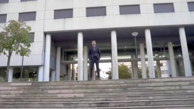 Modern iş adamı, kendine güveni tam yakışıklı iş adamı ofis binasına karşı siyah takım elbiseli, açık hava işçi portresi.
