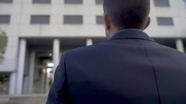 Şehir sokaklarında evrak çantasıyla yürüyen işadamlarının dikiz görüntüsü. Şehirde sabah işe gitmek, kararlılık, güven, yaşam tarzı, yoğun saatler, büyümek ve başarılı olmak..