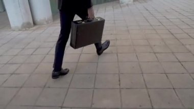 Genç yakışıklı iş adamı evrak çantası tutuyor ve sabah işe gidiyor. Kararlılık, güven, yaşam tarzı, yoğun saatler, büyüyüp başarılı bir konsept.