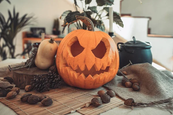 Masada mum ve güneş ışığı olan Cadılar Bayramı hayaleti kabak suratlı. İskelet, mum, fındık. Teal ve turuncu güzel natürmort.