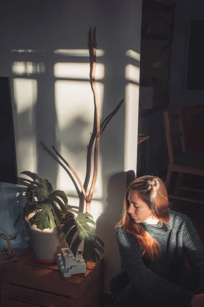 美丽的年轻女子在一个时髦的季风植物旁边 有巨大的叶子和早晨的太阳光在室内 秋天的概念 — 图库照片