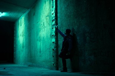 Geceleri karanlık bir sokakta akıllı telefonuyla yalnız bir adam. Tehlike ve korkunç kavram.