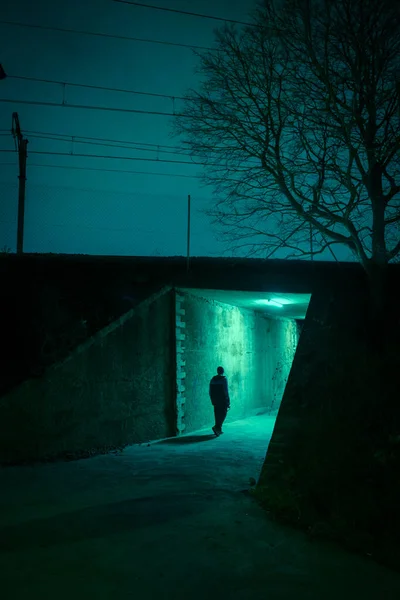 Lonely man in a dark alley at night. Danger and scary concept.