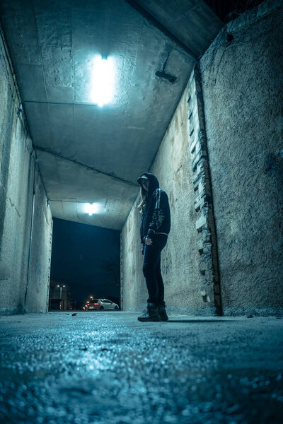 Одинокая женщина, гуляющая в драматическом темном переулке ночью. Опасная и страшная концепция.