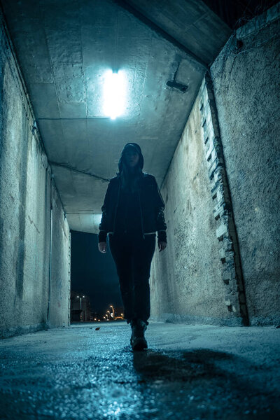 Одинокая женщина, гуляющая в драматическом темном переулке ночью. Опасная и страшная концепция.
