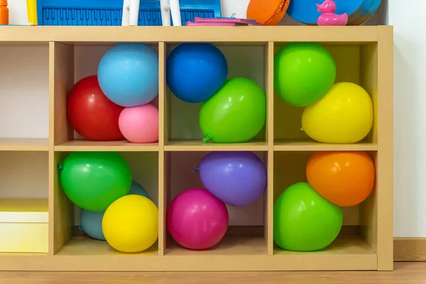 把五彩缤纷的东西 玩具和乐器放在木制架子上 党生动的彩色物体和气球 — 图库照片