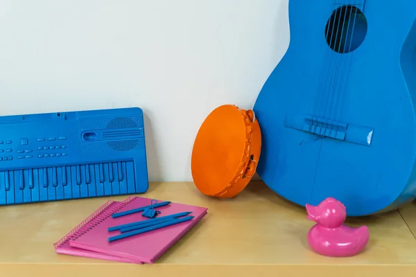 Pop colorful objects, toys and instruments on a wooden shelf. Party vivid color objects and balloons.