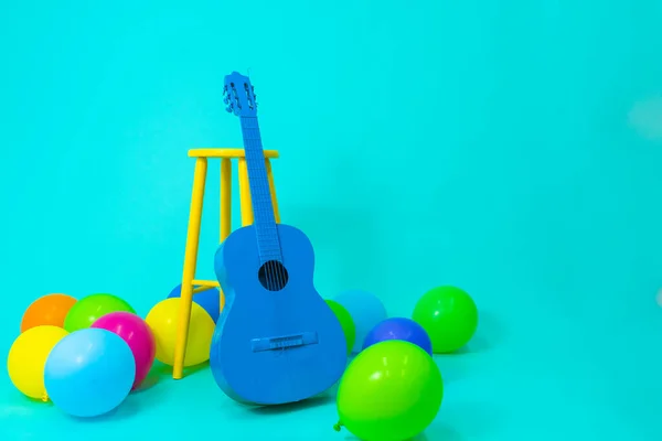 Pop colorful balloons on blue background. Party postcard, vivid color guitar and balloons.