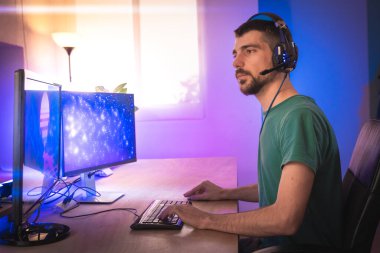 Profesyonel oyuncu kişisel bilgisayarında oyun oynuyor. Retro Arcade Style 'daki Neon Lights' ın aydınlattığı oda. Siber Şampiyonluk. Görüntü Bokeh 'e dönüşür.