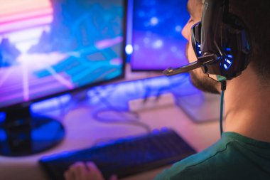 Profesyonel oyuncu kişisel bilgisayarında oyun oynuyor. Retro Arcade Style 'daki Neon Lights' ın aydınlattığı oda. Siber Şampiyonluk. Görüntü Bokeh 'e dönüşür.