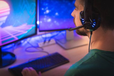 Profesyonel oyuncu kişisel bilgisayarında oyun oynuyor. Retro Arcade Style 'daki Neon Lights' ın aydınlattığı oda. Siber Şampiyonluk. Görüntü Bokeh 'e dönüşür.