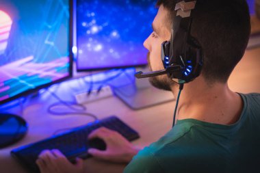 Profesyonel oyuncu kişisel bilgisayarında oyun oynuyor. Retro Arcade Style 'daki Neon Lights' ın aydınlattığı oda. Siber Şampiyonluk. Görüntü Bokeh 'e dönüşür.