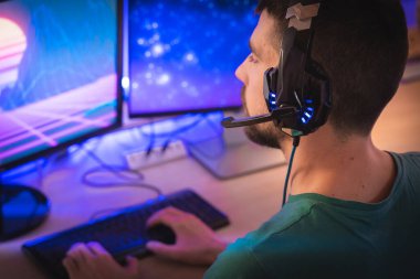 Profesyonel oyuncu kişisel bilgisayarında oyun oynuyor. Retro Arcade Style 'daki Neon Lights' ın aydınlattığı oda. Siber Şampiyonluk. Görüntü Bokeh 'e dönüşür.