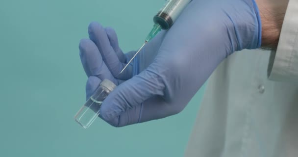 Männlicher Arzt Mit Medizinischer Maske Hält Spritze Mit Coronavirus Impfstoff — Stockvideo