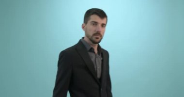 Mavi arka planda izole edilmiş kameraya bakan genç bir iş adamı. Teknoloji konsepti. Metin için Boş Alan