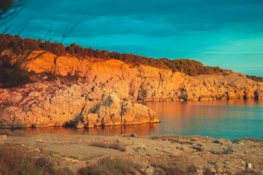 Dağların tepelerinde gün doğumu ve derin mavi okyanuslar. Akdeniz kıyısı.