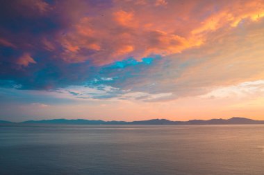 Dağların tepelerinde gün doğumu ve derin mavi okyanuslar. Akdeniz kıyısı.