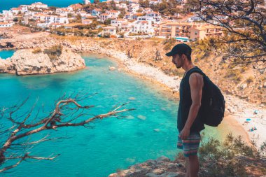 Akdeniz kıyı şeridi manzaralı destansı ve ilham verici genç gezgin dağ kayalıklarından türkuaz suya bakıyor. Katalonya sahilinde yaz tatili. İspanya kıyı şeridinde sırt çantaları.