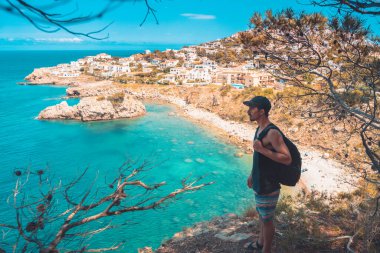 Akdeniz kıyı şeridi manzaralı destansı ve ilham verici genç gezgin dağ kayalıklarından türkuaz suya bakıyor. Katalonya sahilinde yaz tatili. İspanya kıyı şeridinde sırt çantaları.