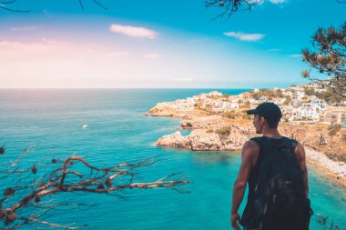 Akdeniz kıyı şeridi manzaralı destansı ve ilham verici genç gezgin dağ kayalıklarından türkuaz suya bakıyor. Katalonya sahilinde yaz tatili. İspanya kıyı şeridinde sırt çantaları.