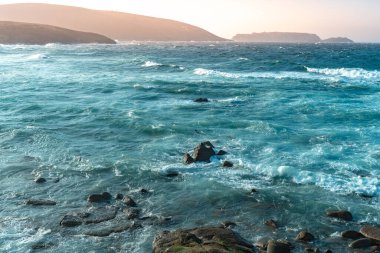 Gün batımında dalgaların inanılmaz gücü kayalara çarpıyor. Büyük okyanus dalgası kıyıları kırıyor. Doğa kavramının güzelliği. Güzel deniz manzarası. Duvar kağıdı, arkaplan.