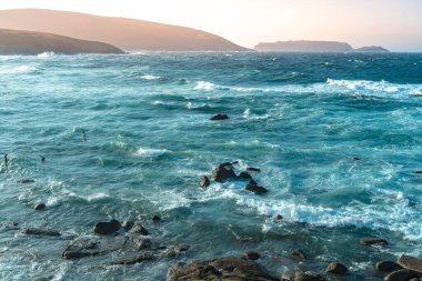 Gün batımında dalgaların inanılmaz gücü kayalara çarpıyor. Büyük okyanus dalgası kıyıları kırıyor. Doğa kavramının güzelliği. Güzel deniz manzarası. Duvar kağıdı, arkaplan.