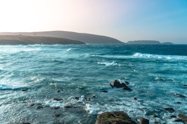 Gün batımında dalgaların inanılmaz gücü kayalara çarpıyor. Büyük okyanus dalgası kıyıları kırıyor. Doğa kavramının güzelliği. Güzel deniz manzarası. Duvar kağıdı, arkaplan.