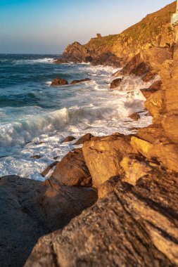 Gün batımında dalgaların inanılmaz gücü kayalara çarpıyor. Büyük okyanus dalgası kıyıları kırıyor. Doğa kavramının güzelliği. Güzel deniz manzarası. Duvar kağıdı, arkaplan.