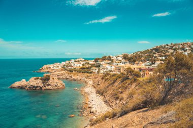 Güzel bir sahil kasabası manzarası ve harika bir kristal mavi okyanus. Akdeniz 'in sarp kayalıklı turkuaz suyu. Seyahat ve tatil konsepti. Arkaplan ve duvar kağıdı.